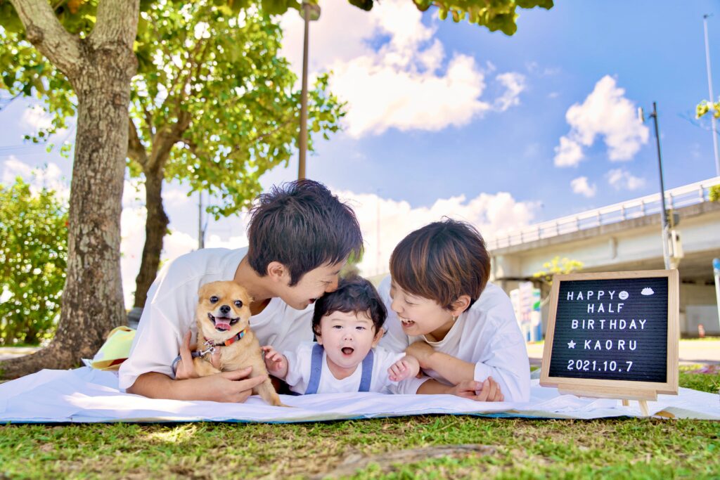 ペットと一緒に芝生でくつろぐ家族写真