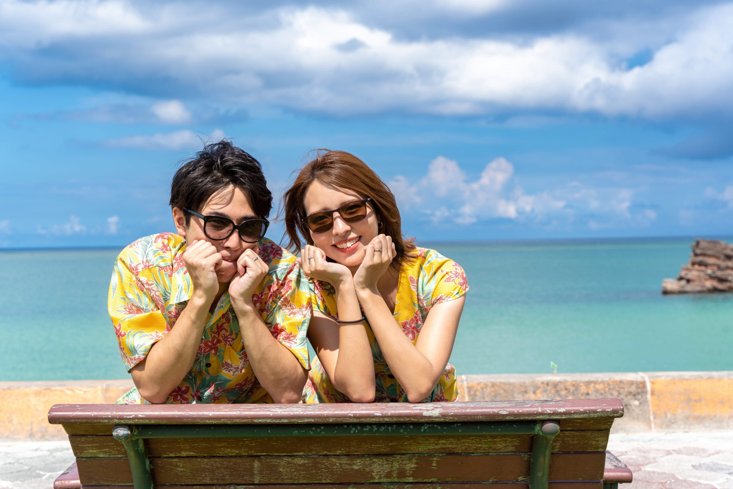 沖縄の海をバックに笑顔のカップル撮影｜リンクコーデでビーチフォト