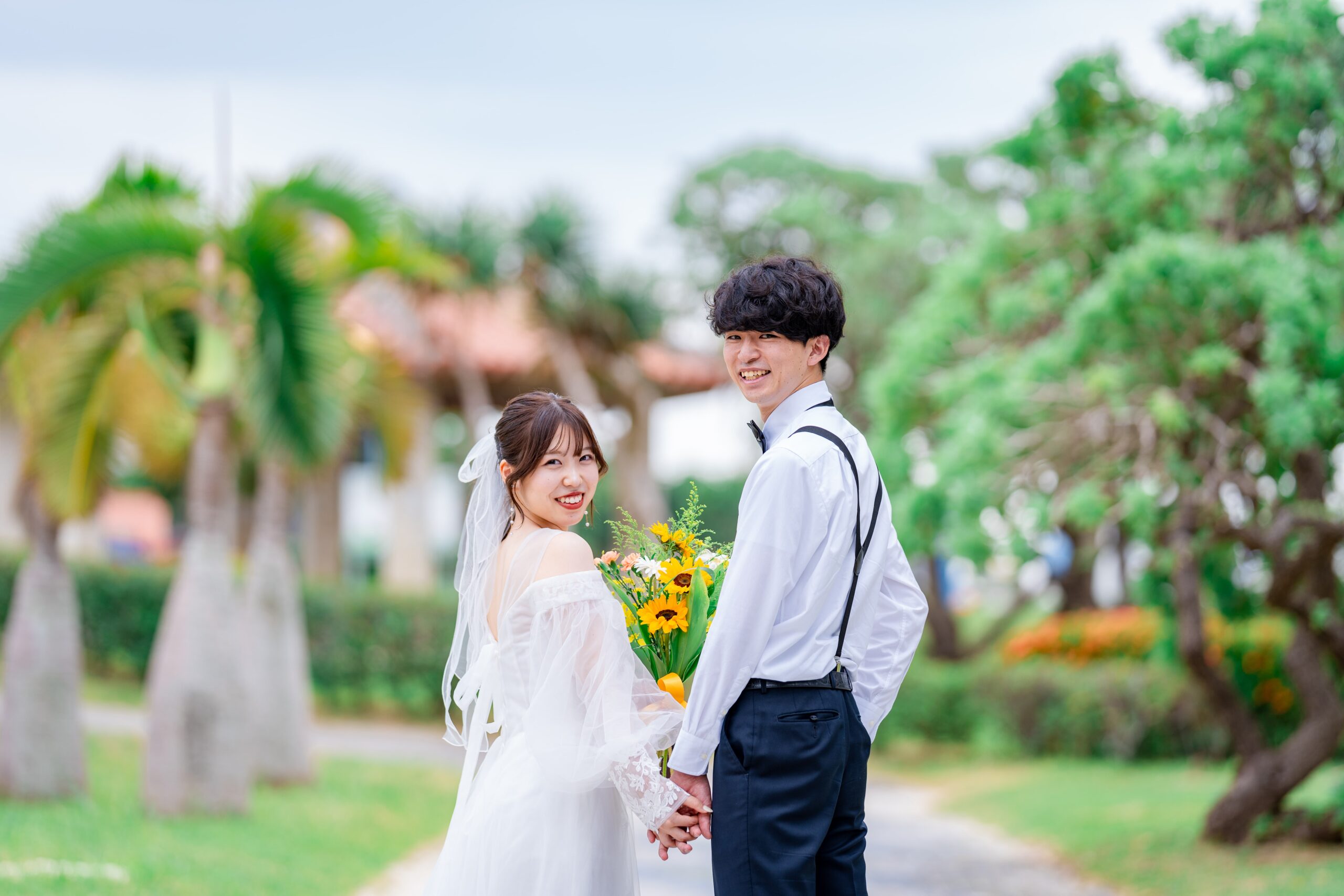 琉装姿のカップルと沖縄の伝統的な赤い建物