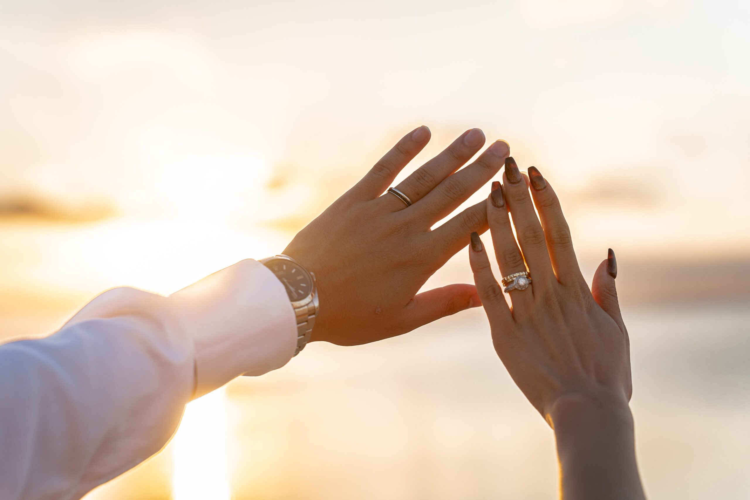 夕日のビーチでシルエットになった新郎新婦