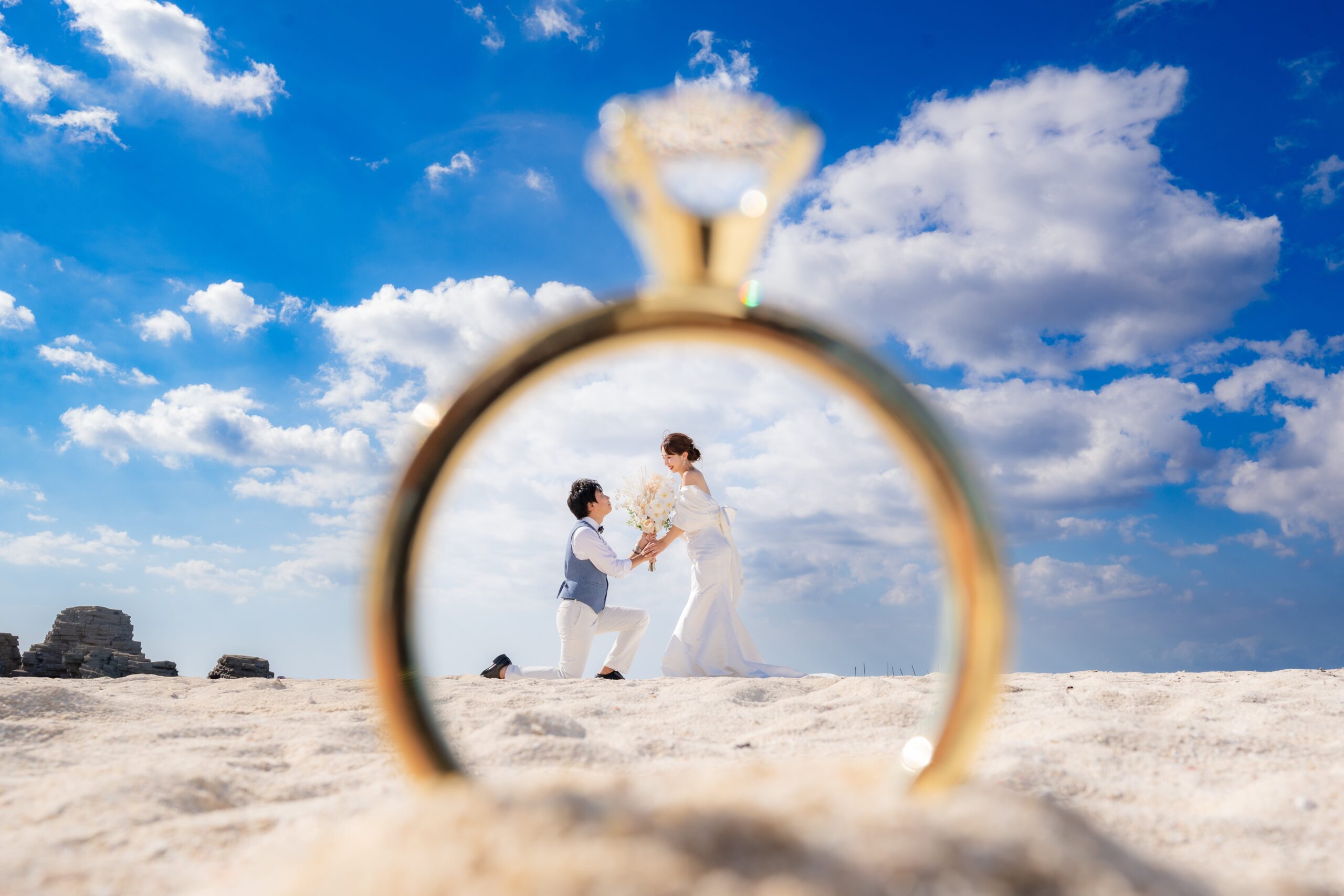 沖縄の海と青空を背景にした結婚指輪のクローズアップ