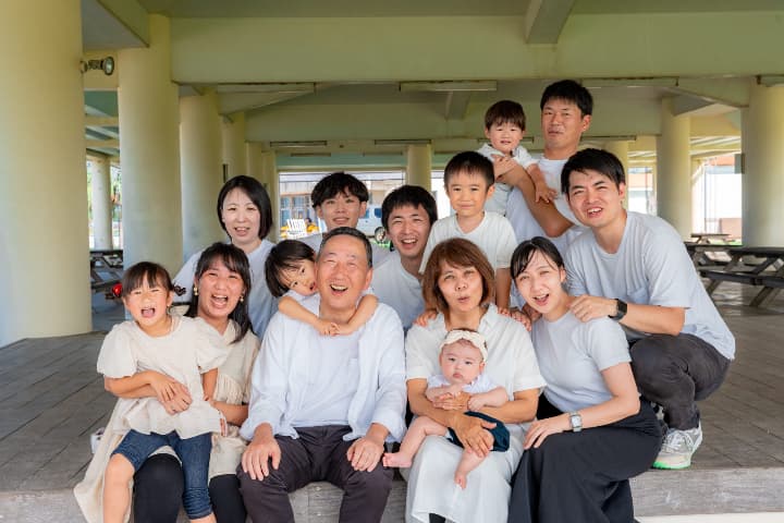 屋根の下で笑顔あふれる家族の集合写真