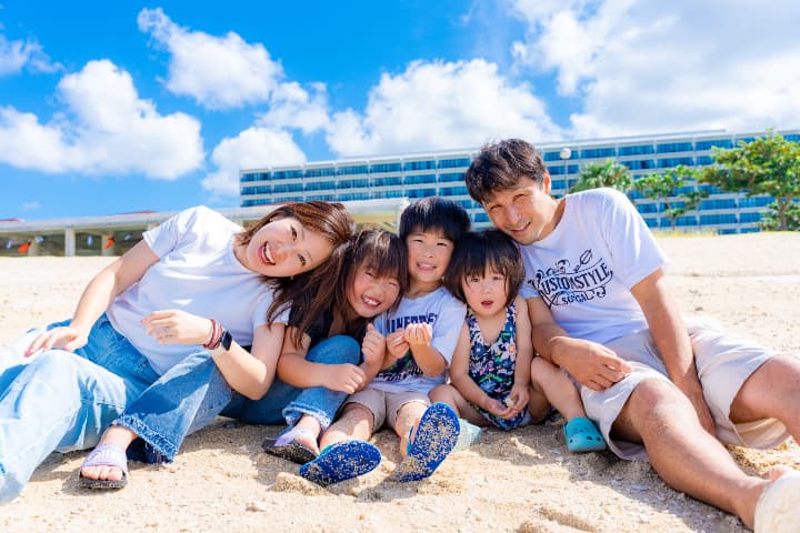 海辺で撮影された大家族の集合写真