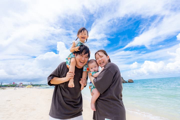 沖縄の青い空と青い海をバックに肩車する家族のファミリーフォト｜沖縄家族写真