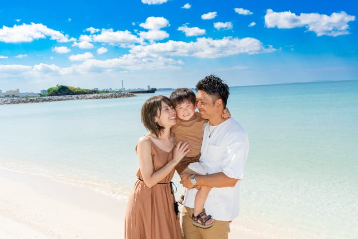 沖縄のビーチで出張撮影を楽しむ3人家族の笑顔の家族写真