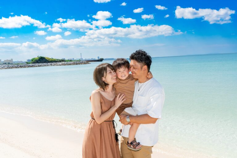 沖縄のビーチで家族みんなで顔を近づけ合う幸せいっぱいの家族写真｜沖縄ビーチフォト
