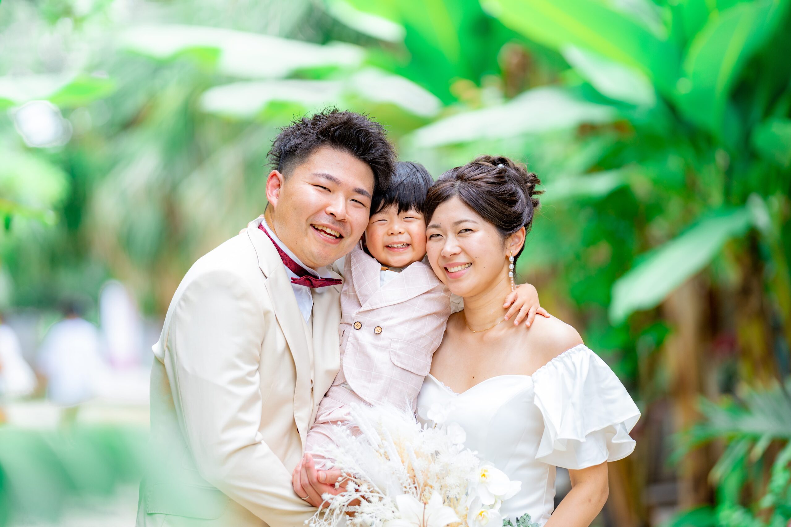 大きなガジュマルの木の下で自然光に包まれた新郎新婦