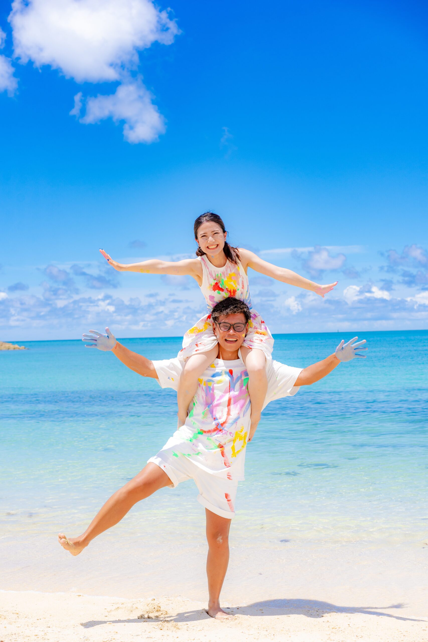 沖縄ペイントフォト｜沖縄の海でカップルが肩車して絵の具まみれの体験撮影