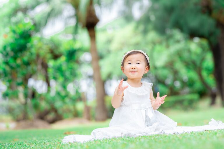 沖縄の緑をバックに1歳記念の出張撮影をした家族写真｜沖縄出張撮影