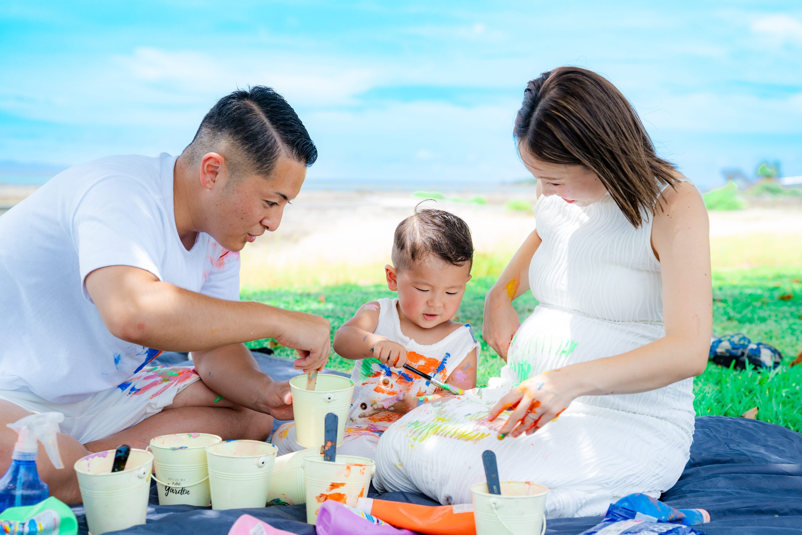 沖縄ペイントフォト｜ママの洋服にも絵の具をぬりぬりする子どもの可愛い家族撮影
