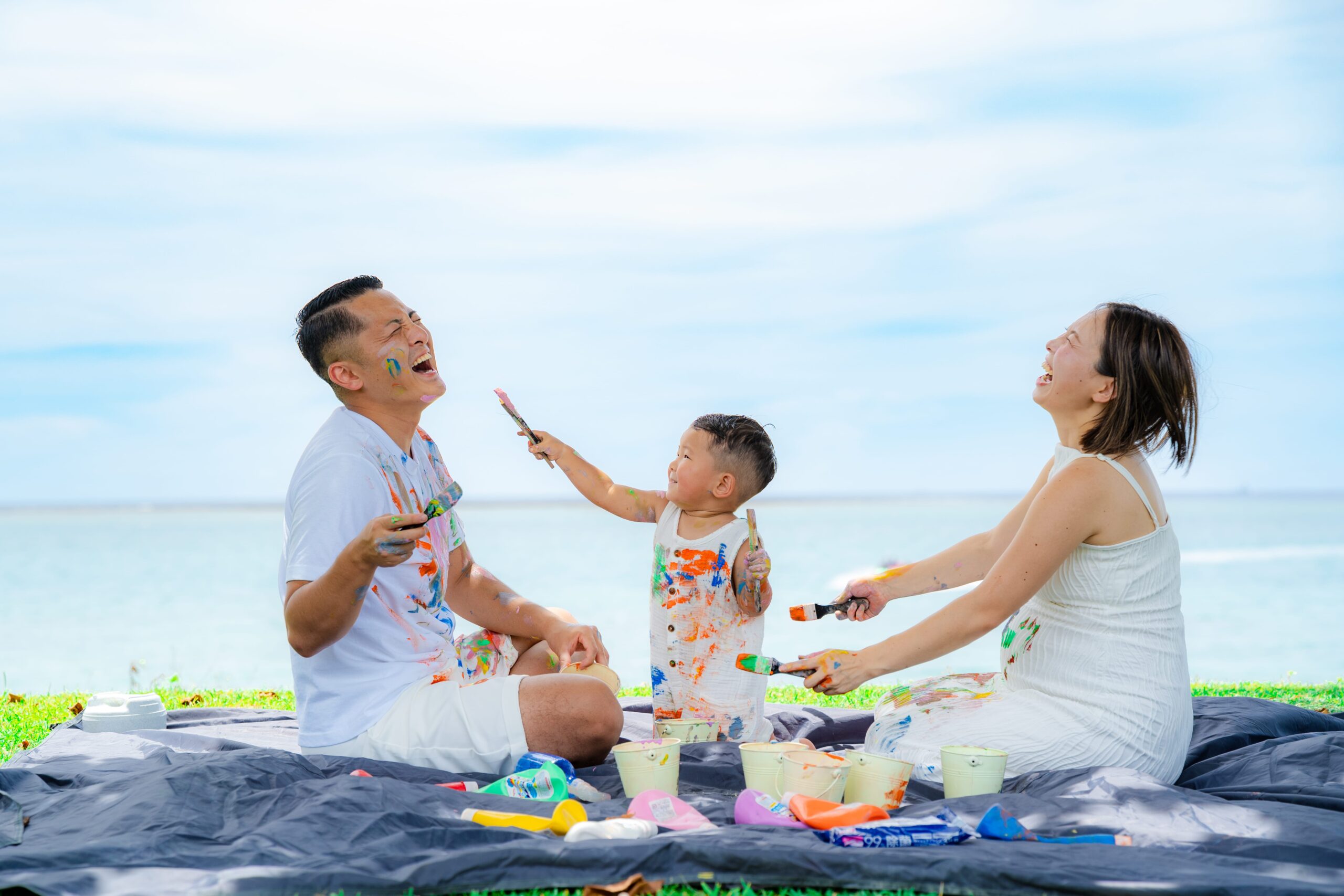 沖縄ペイントフォト｜絵の具遊びで笑顔が溢れる家族の微笑ましいビーチ撮影