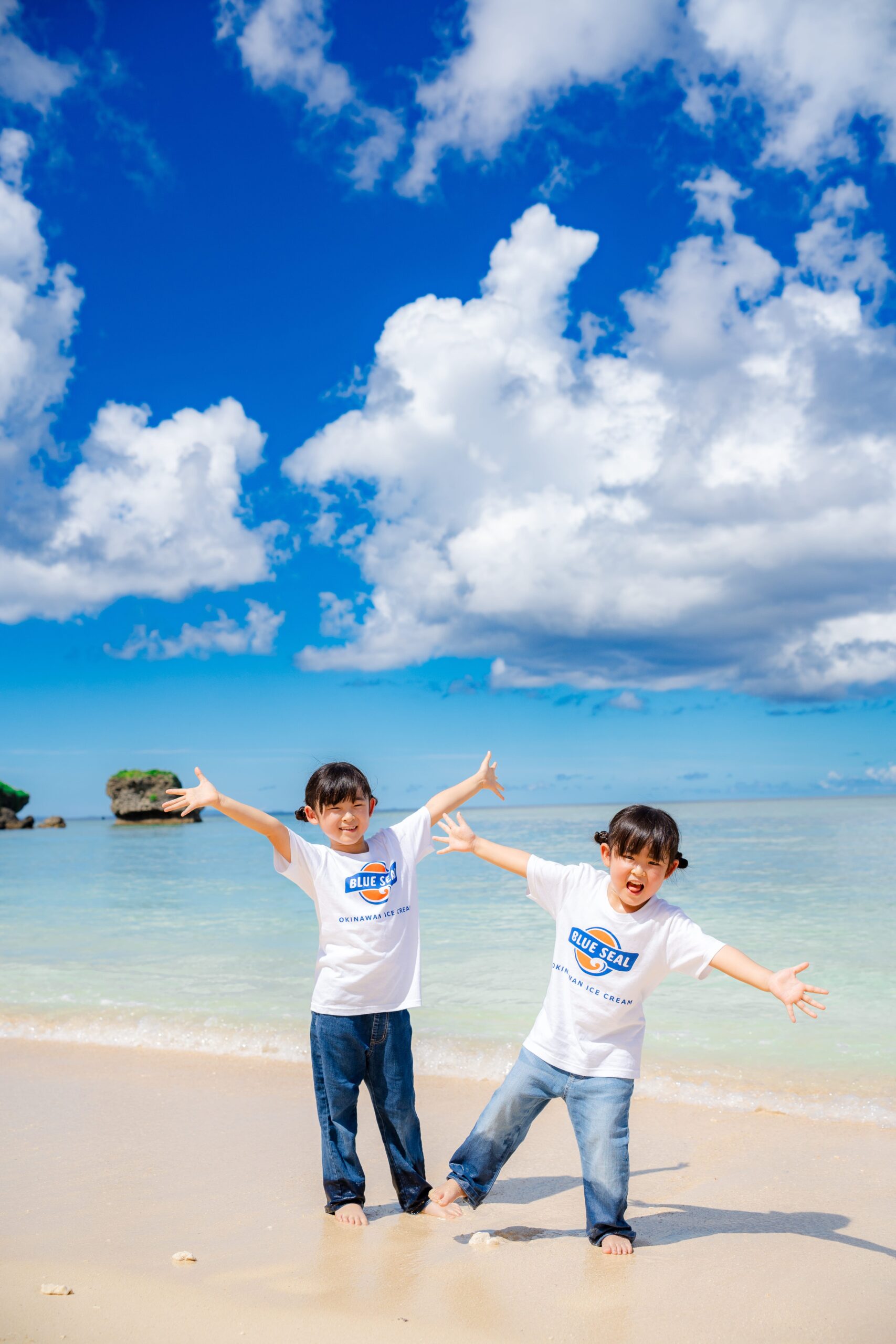 沖縄の海で子ども2人が手を広げて遊ぶ元気いっぱいの家族写真｜沖縄ビーチフォト