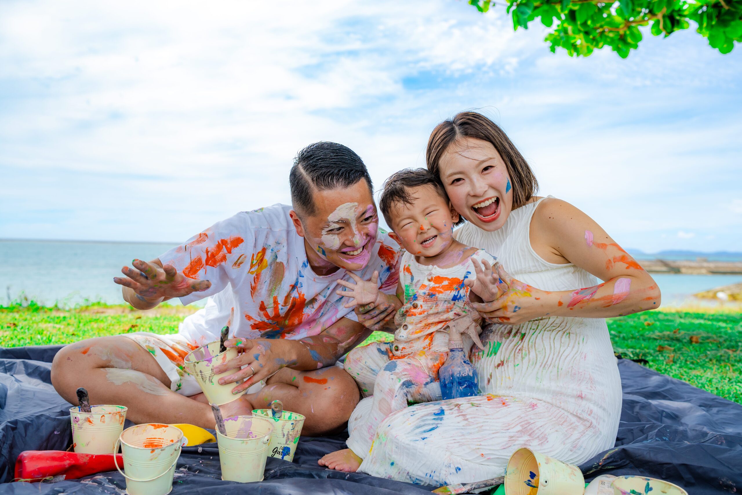 沖縄ペイントフォト｜木陰で真夏でも快適に家族ペイントフォトを楽しむ様子