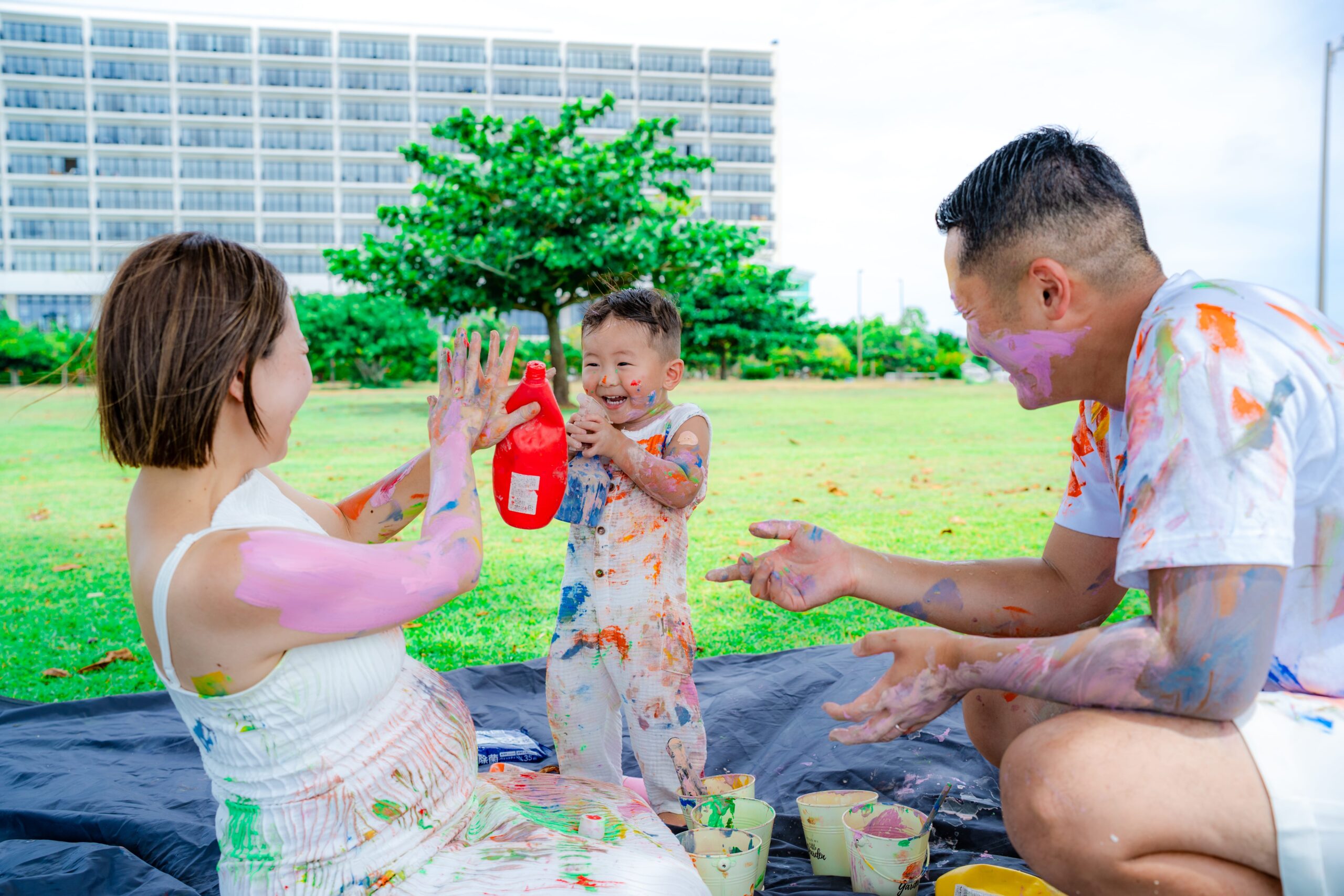沖縄ペイントフォト｜家族三人でカラフルな絵の具を塗り合い楽しむビーチ撮影