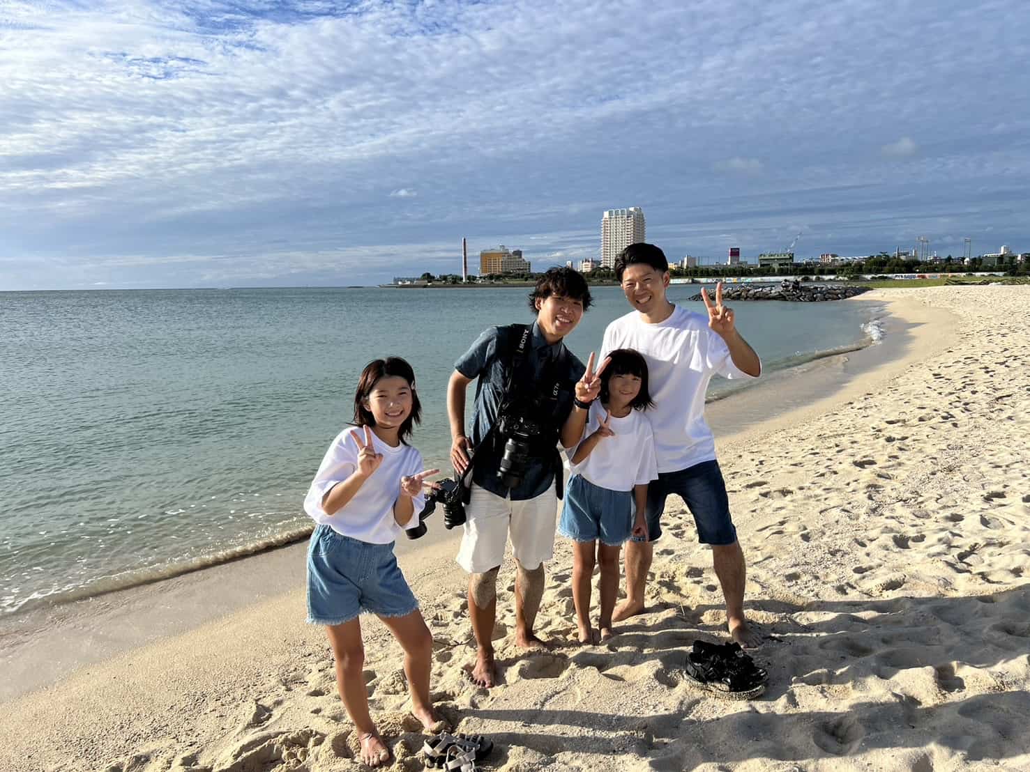 沖縄出張撮影カメラマンとっくーとお客様の記念写真｜ビーチでの家族撮影後