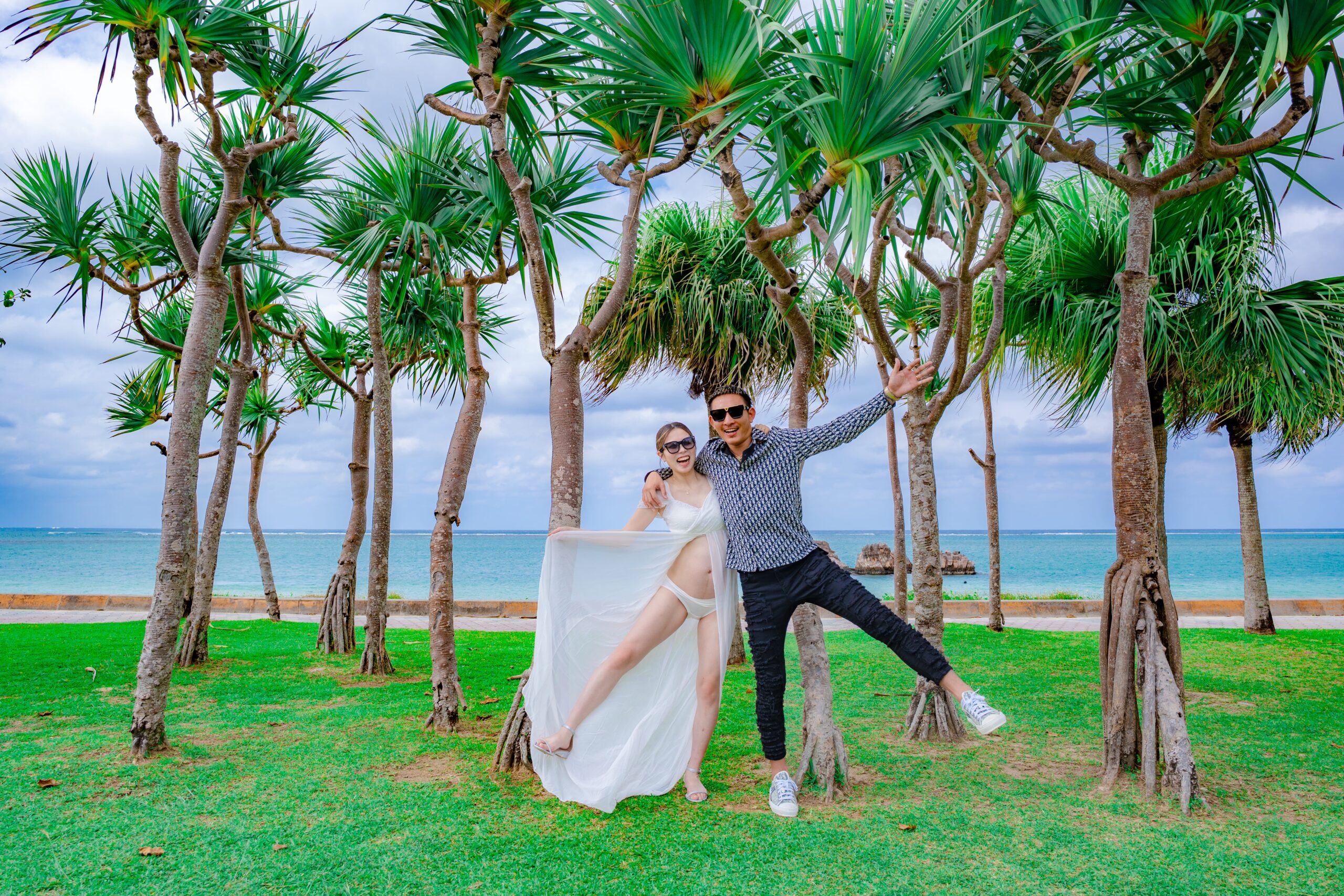 沖縄マタニティフォト｜緑エリアで二人で沖縄と叫ぶ元気な夫婦撮影