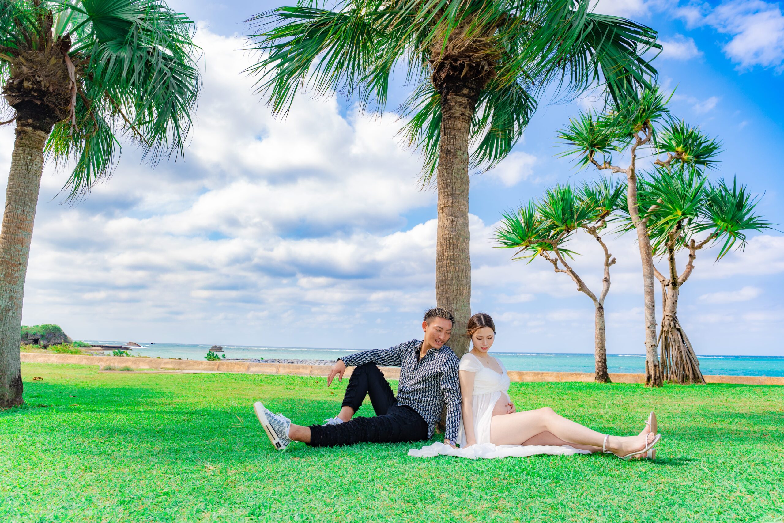 沖縄マタニティフォト｜ヤシの木にもたれる二人のリラックス撮影
